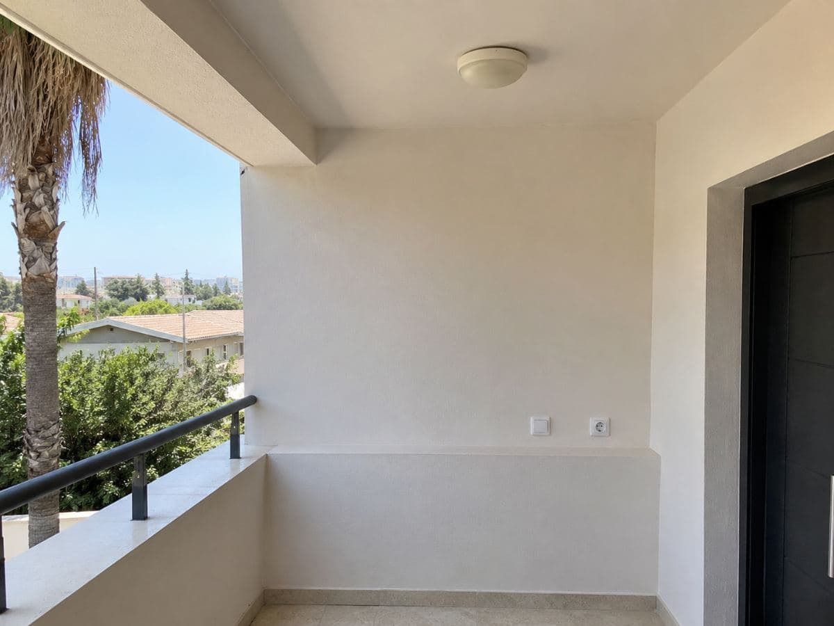 מרפסת מקורה אחרי תיקוני טיח וצביעה בגוון בהיר אחיד