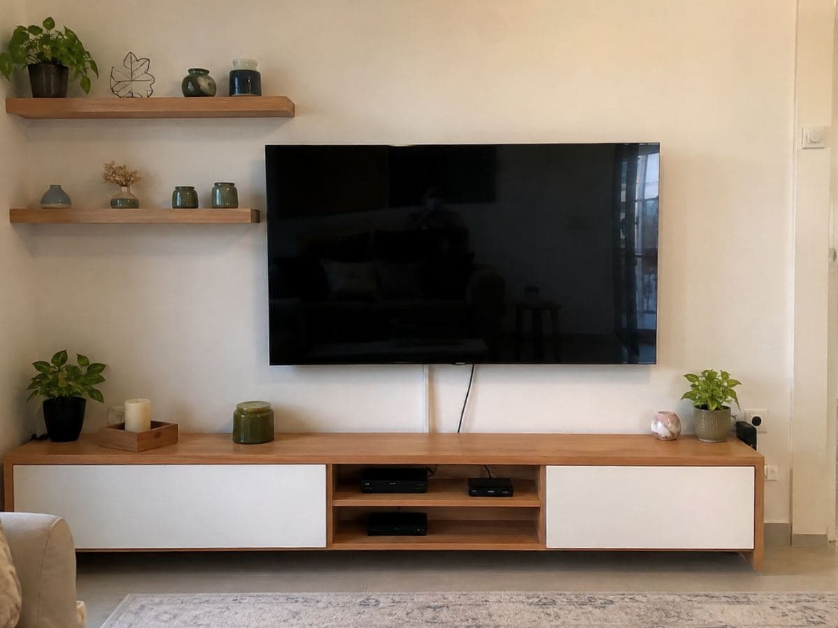טלוויזיה תלויה על הקיר מעל מזנון עץ, עם שני מדפים צפים בצד